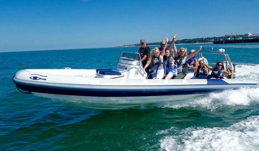 Friends cheering on a RIB speeding along the coast
